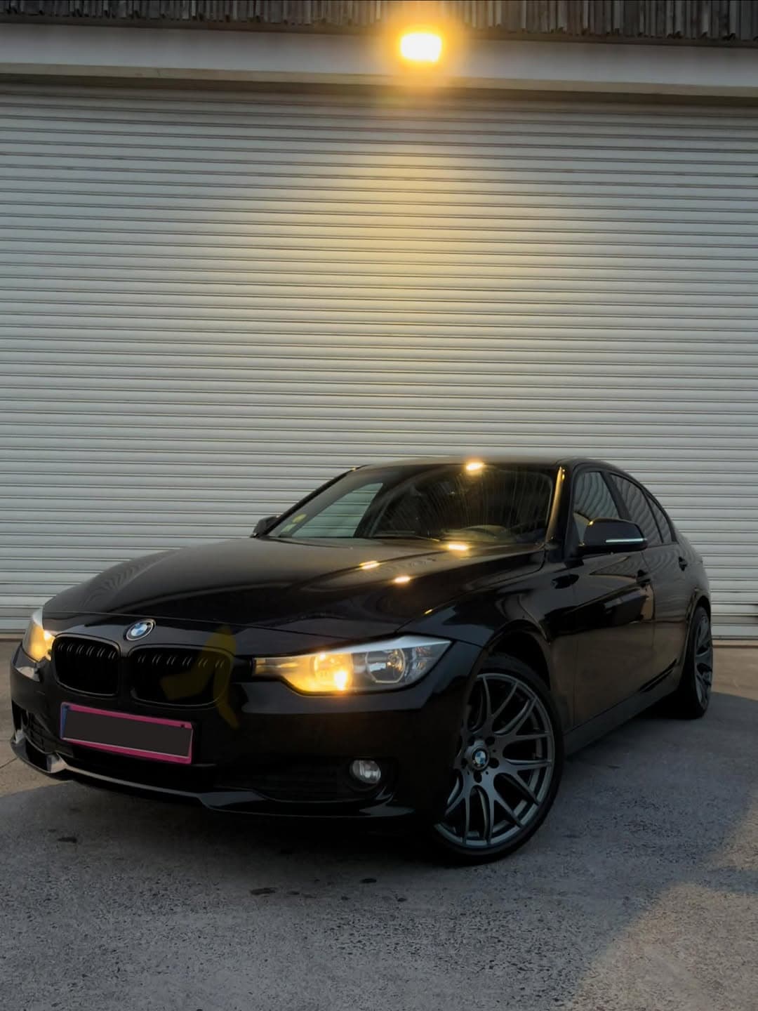 BMW Série 3 noire devant le showroom Heocar